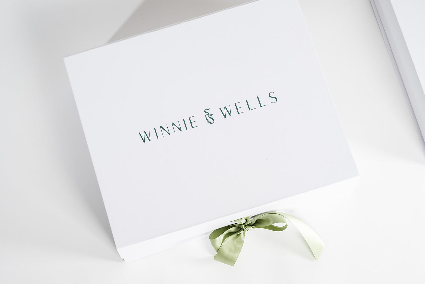 White box with 'Winnie & Wells' branding and a green ribbon on a light gray background