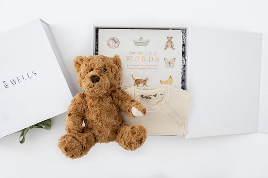 decorative image with teddy bear, first words book and cream knit set in a gift box