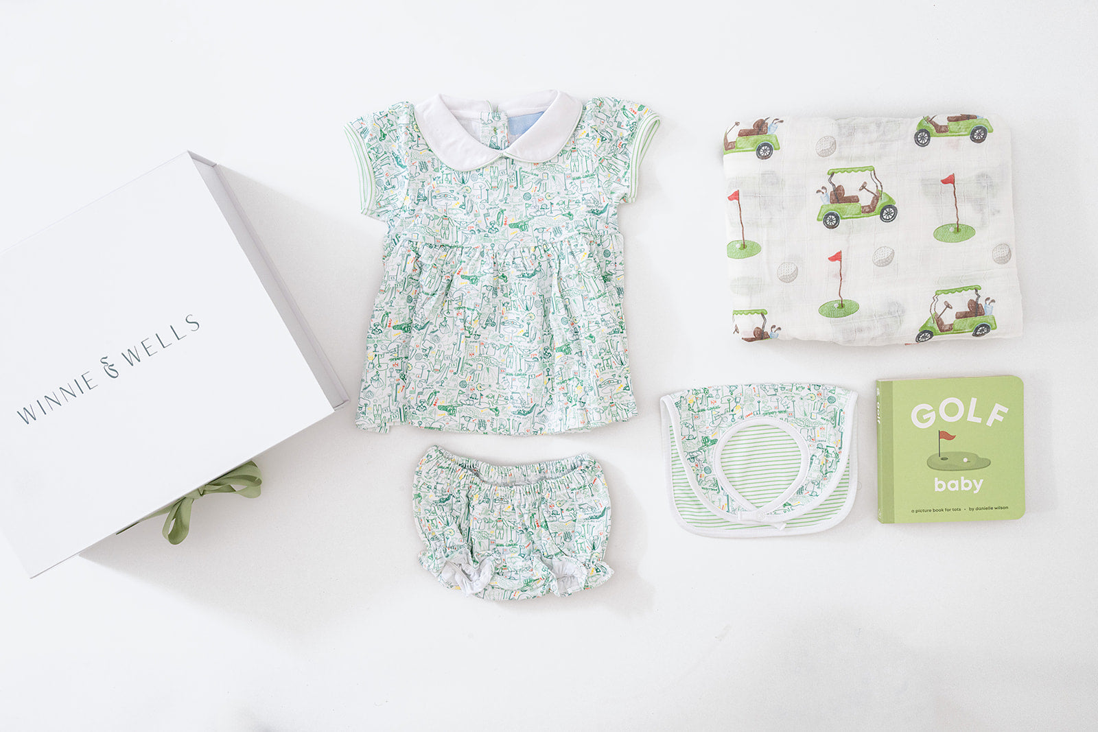 Decorative image layout of golf-themed baby dress, bloomers, and matching bib, golf-print swaddle blanket and "Golf Baby" board book. 