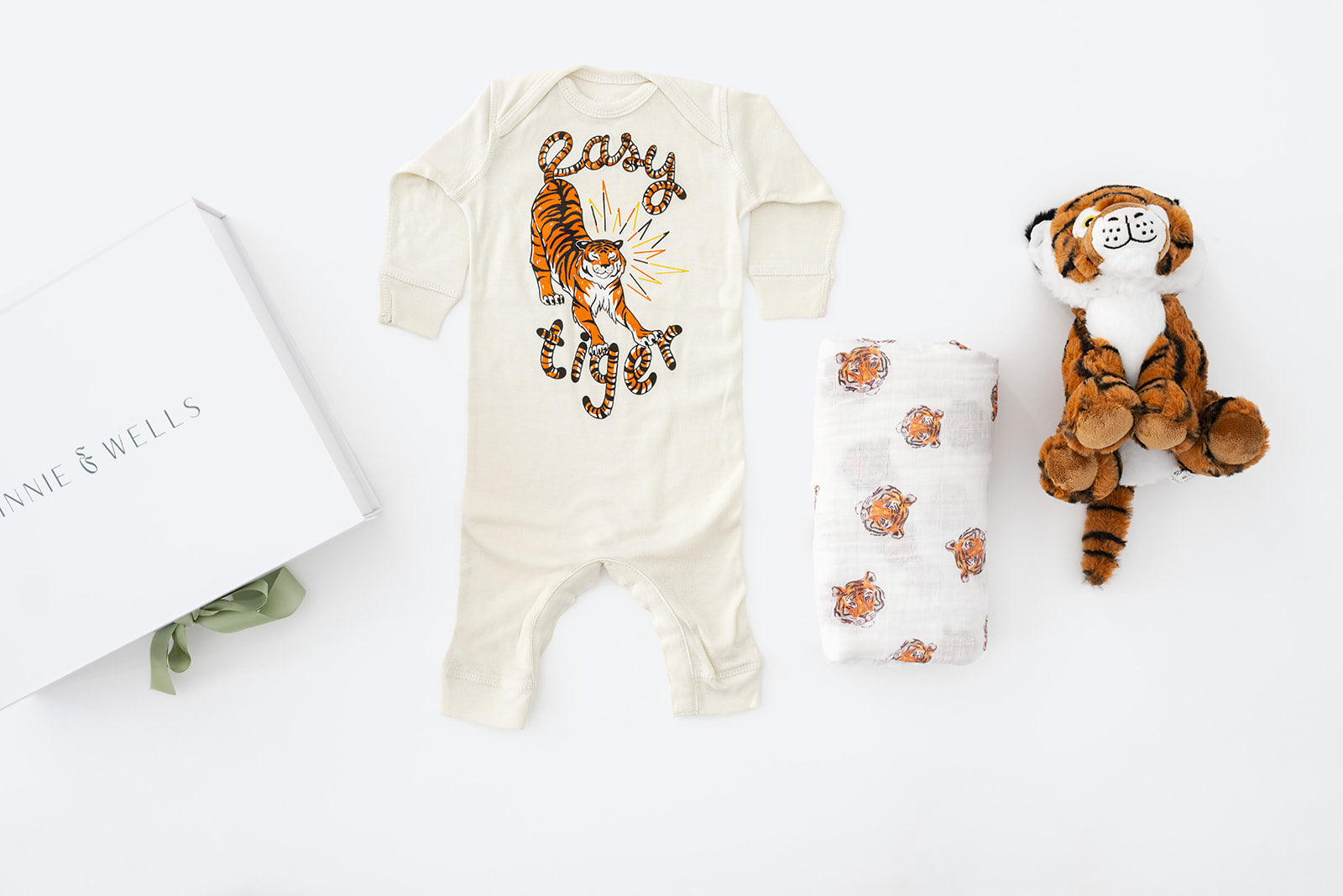 Baby onesie with tiger design, matching blanket, and plush toy on a white background