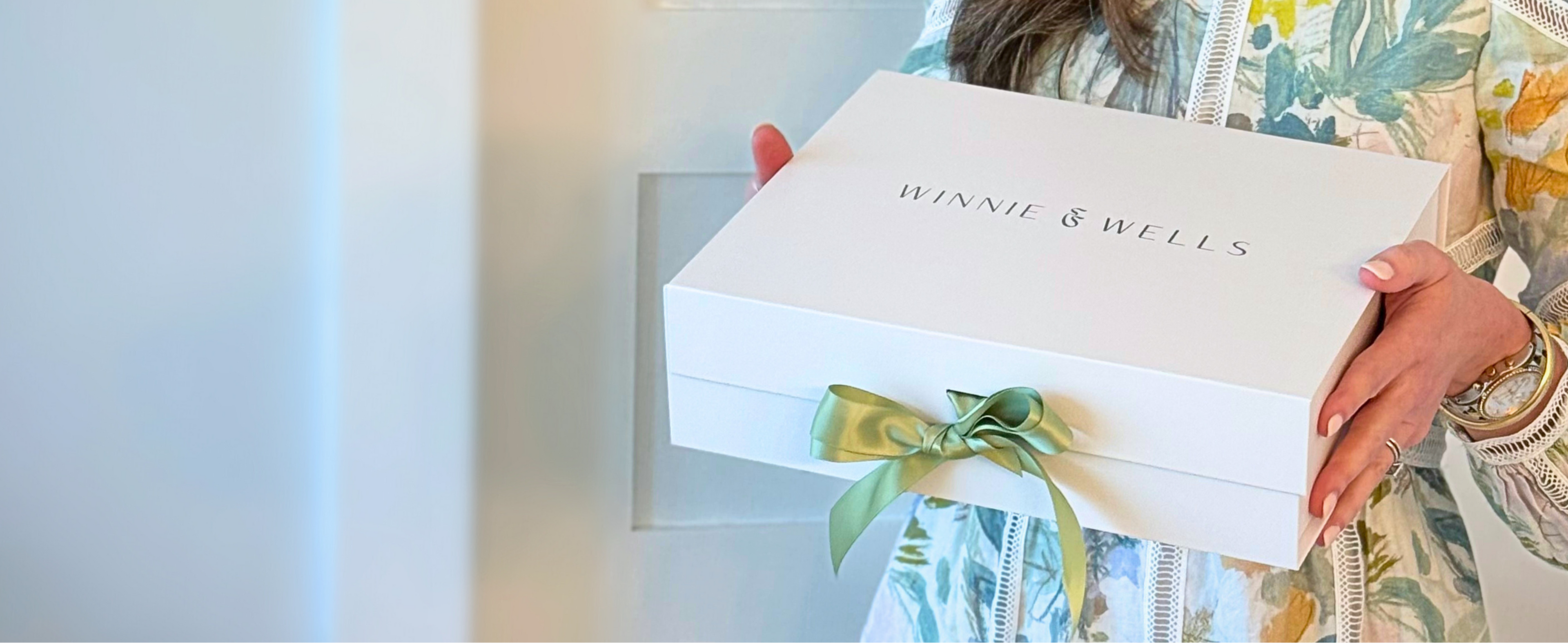 Person holding a box with 'Winnie & Wells' branding